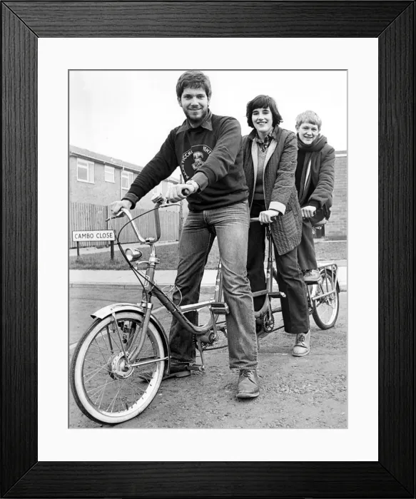 Framed Print : Trying the goodies style triplet bike out for size are (left to right Framed Print : Trying the goodies style triplet bike out for size are (left to right
