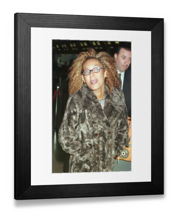 Framed Print : Mel B of the Spice Girls showing the two rings in her tongue as she went through Heathrow