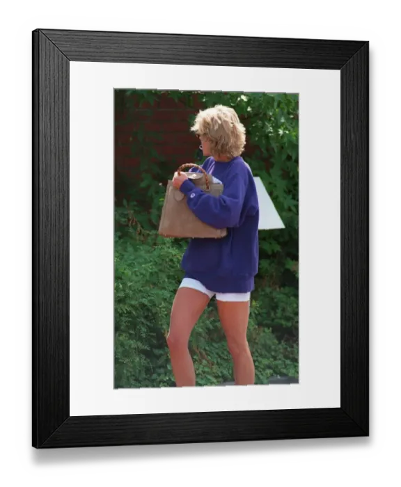 Framed Print : Princess Diana holding a key ring in her mouth, turns her head away as she leaves her gym