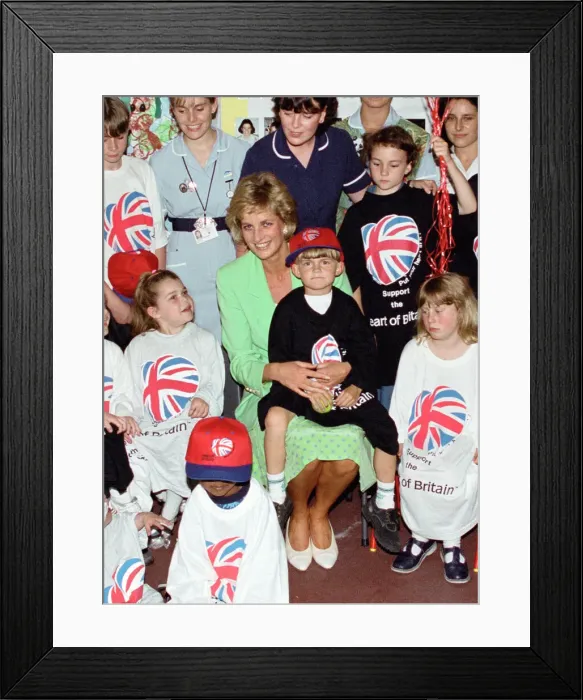 Framed Print : Diana, Princess of Wales sits with with Jamie Poore on her lap on a visit to a