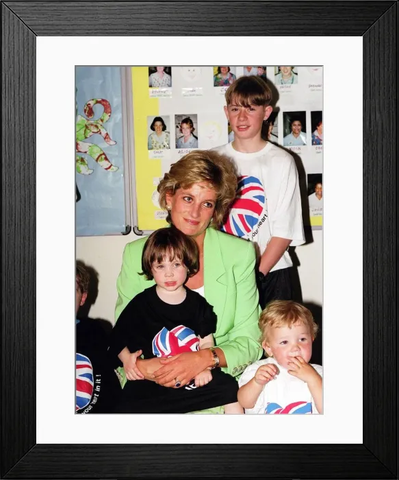 Framed Print : Princess Diana sitting with Caitlin Hines on her lap during a visit to a children