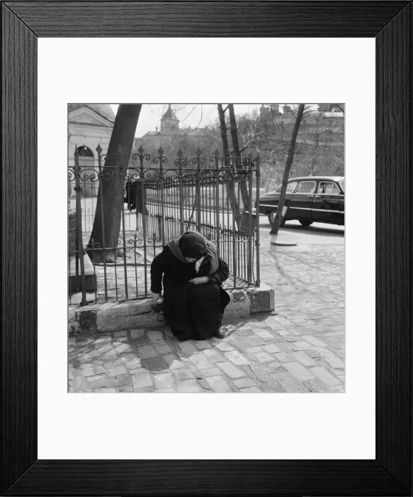 Framed Print : An elderly female resident of the Soviet city of Kiev, sitting on a low wall in one of Framed Print : An elderly female resident of the Soviet city of Kiev, sitting on a low wall in one of