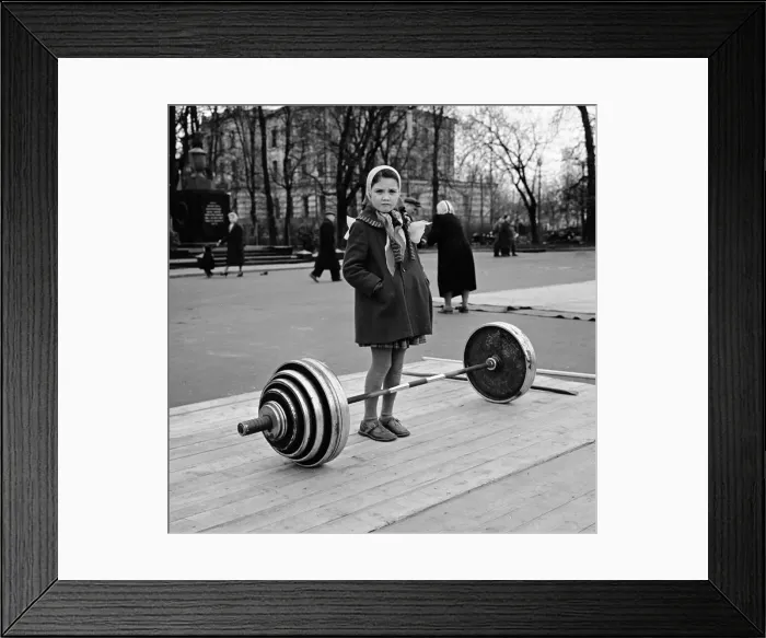 Framed Print : Russian girl contemplates the dumb bell weights used by the weightlifters in a Moscow Framed Print : Russian girl contemplates the dumb bell weights used by the weightlifters in a Moscow