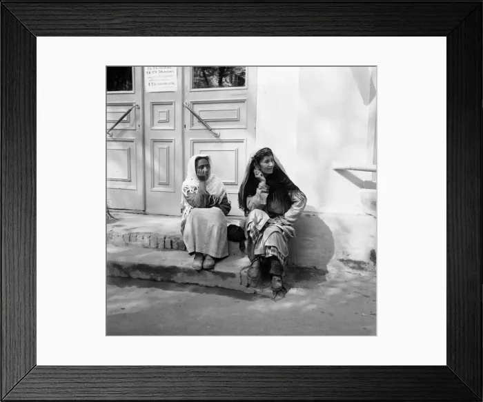 Framed Print : Two women sitting on the steps of a shop watch the May Day parade in the Russian town of Framed Print : Two women sitting on the steps of a shop watch the May Day parade in the Russian town of