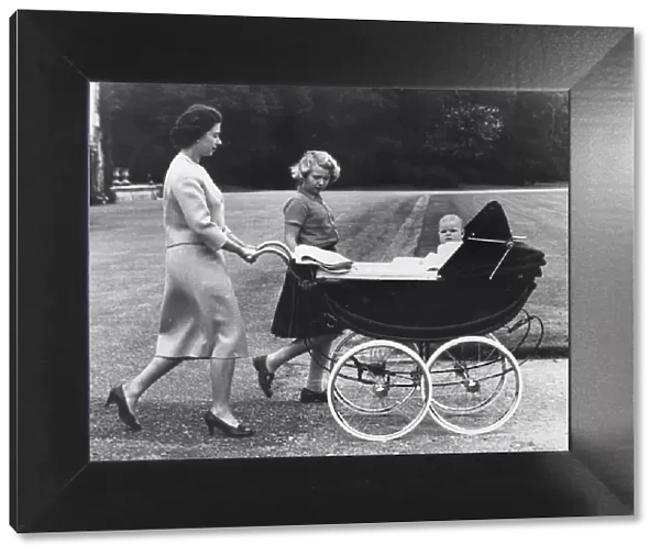 Queen Elizabeth II and Princess Anne take baby Prince Andrew for a ride in his high pram