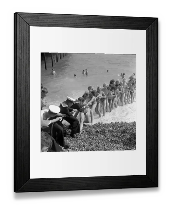 Framed Print : Beauty contest girls playing tug of war with a group of sailors at Southsea, UK Framed Print : Beauty contest girls playing tug of war with a group of sailors at Southsea, UK