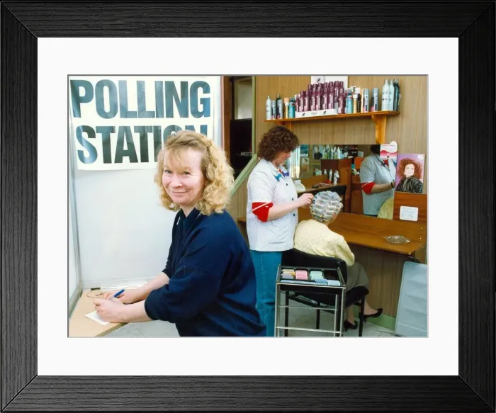 Framed Print : One of the hairdressers casting her vote at the polling station in her salon while staff Framed Print : One of the hairdressers casting her vote at the polling station in her salon while staff