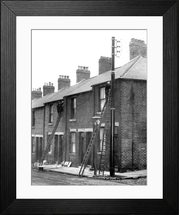 Framed Print : Workmen busy at the poles erected in Shield Street, Gateshead where they are putting Framed Print : Workmen busy at the poles erected in Shield Street, Gateshead where they are putting