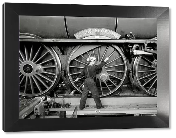 Railway worker shows the scale of the wheels on the Flying Scotsman steam train