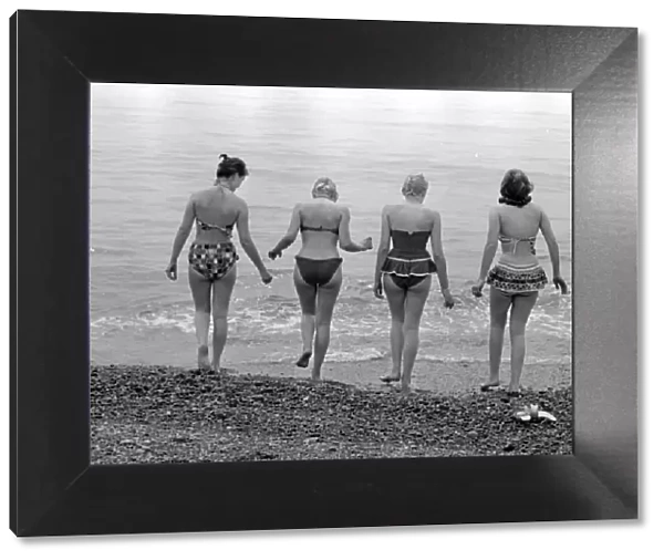 A group of women go for a swim on the beach at Brighton beach July 1958