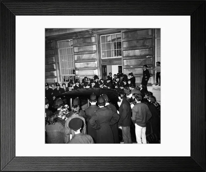 Framed Print : Fans of The Beatles watch as policemen escort group to their car Framed Print : Fans of The Beatles watch as policemen escort group to their car
