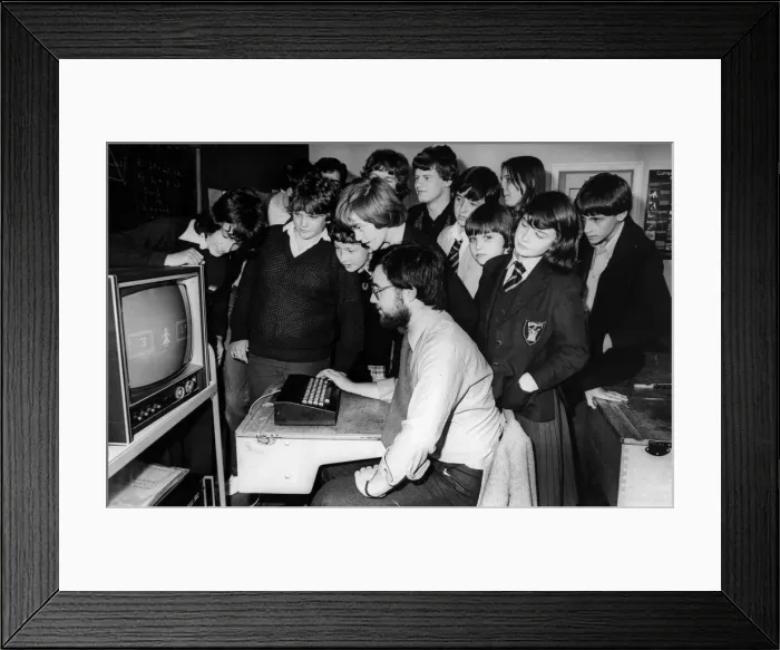Framed Print : Children using computers. The mother of one of the pupils at Benfield Road School