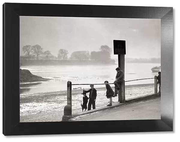 Children playing on the banks of the River Thames, Chiswick, London