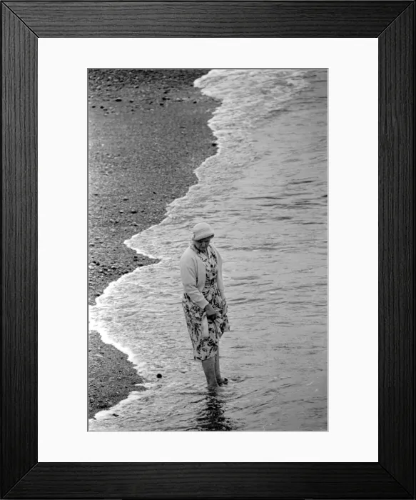 Framed Print : A woman goes for a paddle in the sea on the beach at Brighton July 1958