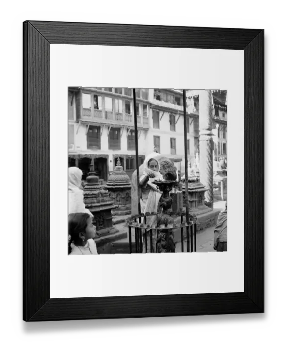 Framed Print : A woman pilgrim seen here lighting candles at a Buddhist Stupa temple in Kathmandu in Framed Print : A woman pilgrim seen here lighting candles at a Buddhist Stupa temple in Kathmandu in