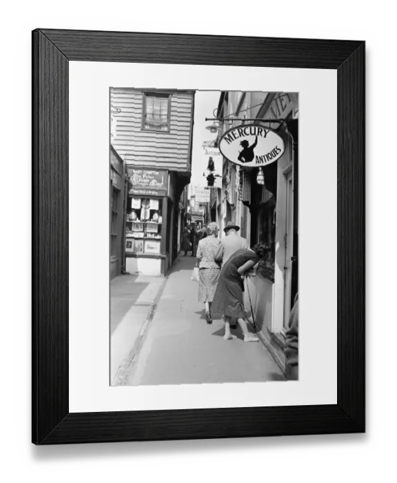 Framed Print : A customer looking through the window of antique dealers shop in The Lanes in Brighton