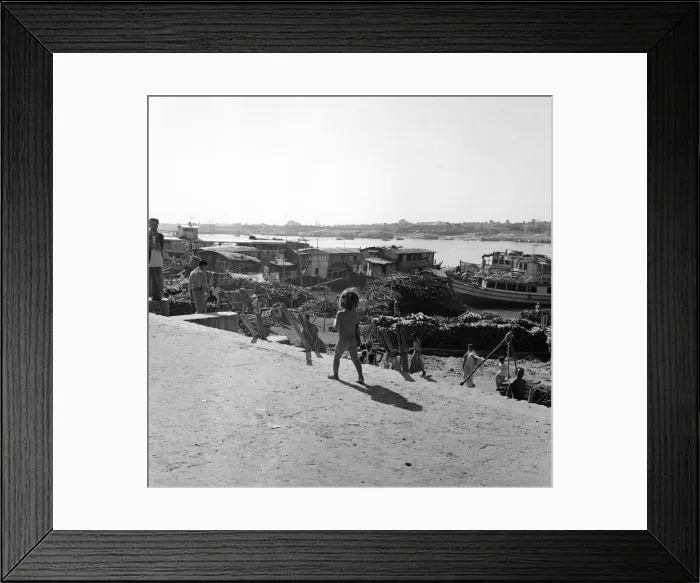 Framed Print : A child watches the boats unloaded in Dacca, Bangladesh. February 1961 l