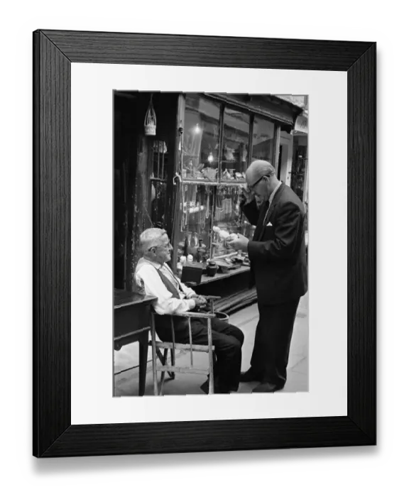 Framed Print : An antique dealers talking to a customer outside his shop in The Lanes in Brighton