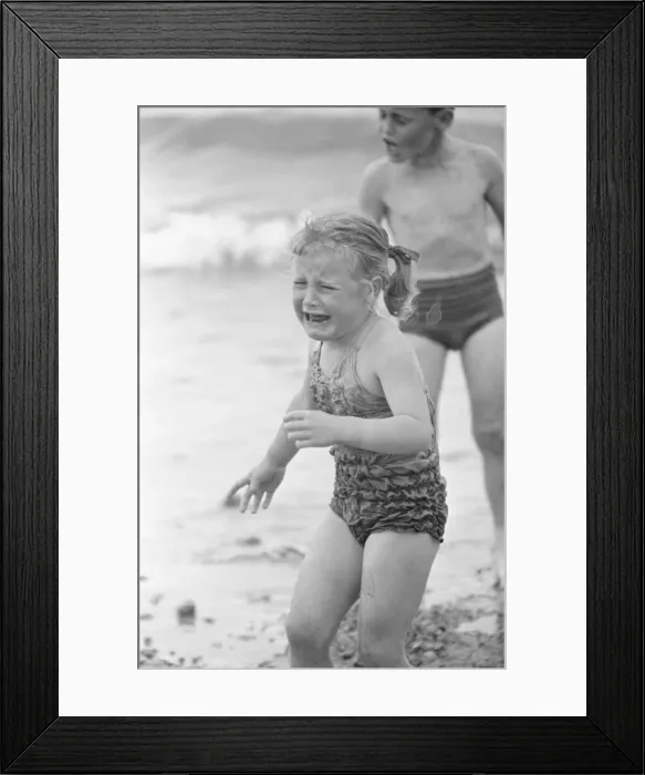 Framed Print : Tears for this young girl as she goes for a paddle in the sea on the beach at Brighton