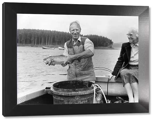 Jack Charlton releases one of the tagged trout at Kielder Reservoir with his mam Cissie