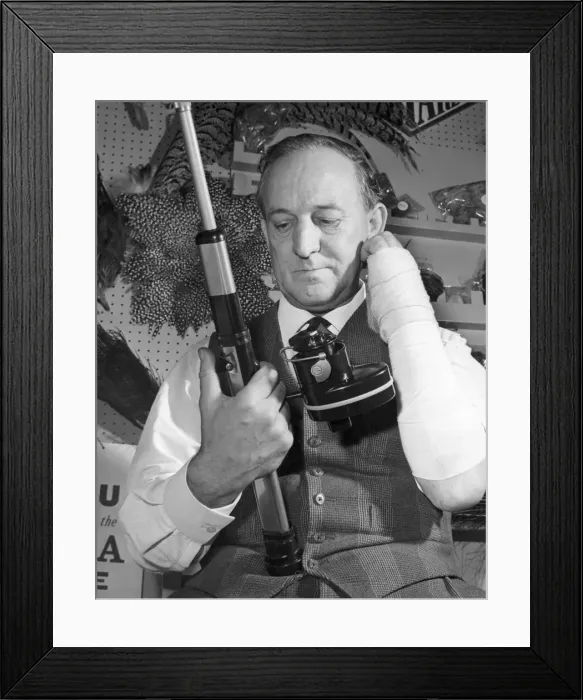 Framed Print : Mr Charles Wade looking at the new motorised fishing reel which can be used by one armed Framed Print : Mr Charles Wade looking at the new motorised fishing reel which can be used by one armed
