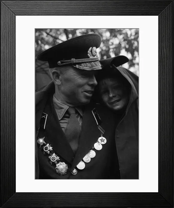 Framed Print : A soldier shelters his son from the rain under his greycoat during the May Day Framed Print : A soldier shelters his son from the rain under his greycoat during the May Day