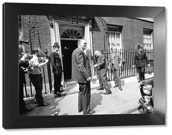 Prime Minister Edward Heath is rushed back inside Number 10 Downing Street watched by