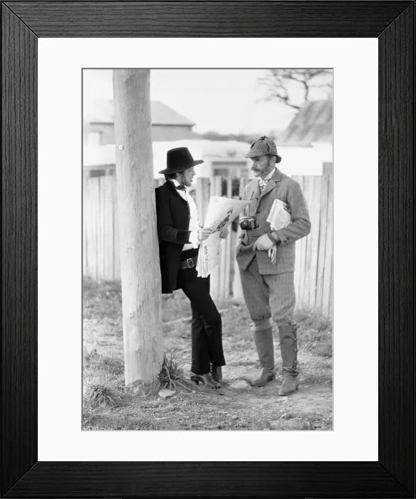 Framed Print : Rolling Stones singer Mick Jagger relaxes by reading a newspaper as he talks to Framed Print : Rolling Stones singer Mick Jagger relaxes by reading a newspaper as he talks to