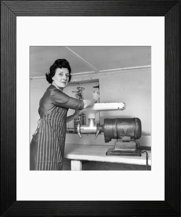 Framed Print : A female butcher seen here at work in her shop, using the mincer. 1963 Framed Print : A female butcher seen here at work in her shop, using the mincer. 1963