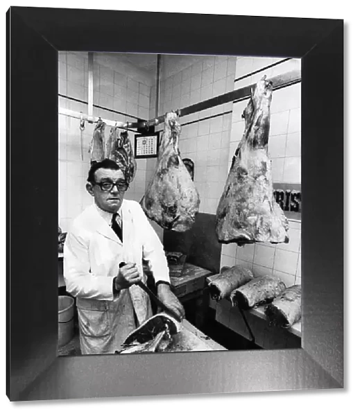 Butcher Bert Sibbet cutting joints in his shop. November 1974