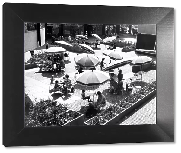 Shoppers relaxing below the circular Godiva Cafe in the Lower Precinct