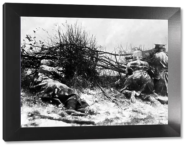 British soldiers firing a machine gun from behind a hedge in the snow