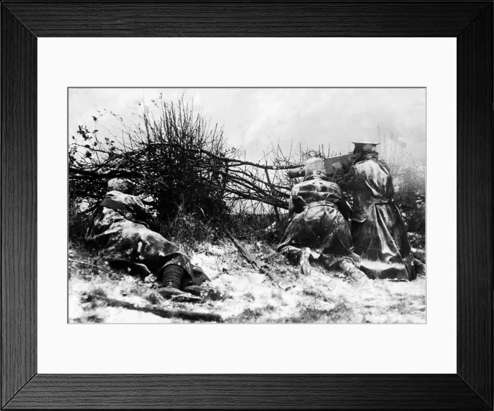 Framed Print : British soldiers firing a machine gun from behind a hedge in the snow