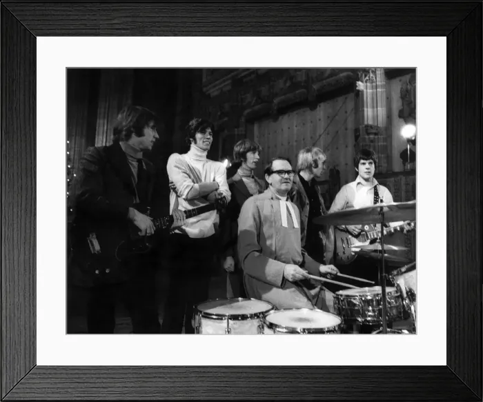 Framed Print : The Bee Gees pop group stand behind a vicar having a a go on the drums during rehearsals