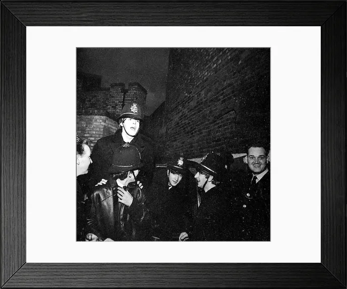 Framed Print : The Beatles clowning around, dressed in policemen helmets used to smuggle them into Framed Print : The Beatles clowning around, dressed in policemen helmets used to smuggle them into