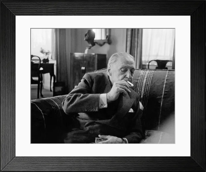 Framed Print : British writer William Somerset Maugham photographed smoking a cigarette at his home Framed Print : British writer William Somerset Maugham photographed smoking a cigarette at his home