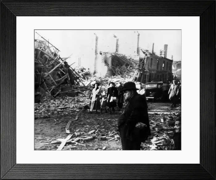 Framed Print : Survivors from the previous nights bombing seen here walking through the wreckage of