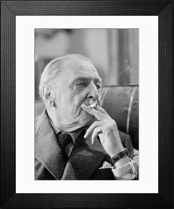 Framed Print : British writer William Somerset Maugham photographed smoking a cigarette at his home Framed Print : British writer William Somerset Maugham photographed smoking a cigarette at his home