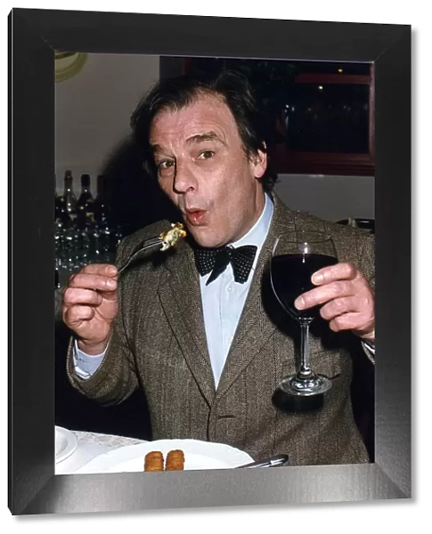 Keith Floyd Television Chef sampling pub food whilst holding a glass of red wine