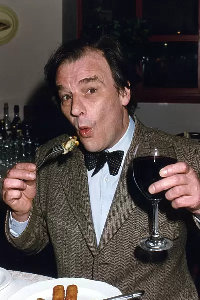 Keith Floyd Television Chef sampling pub food whilst holding a glass of red wine