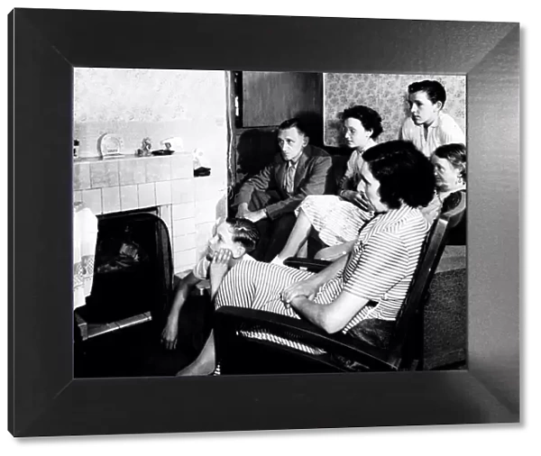 A family watch television together in their living room circa 1950