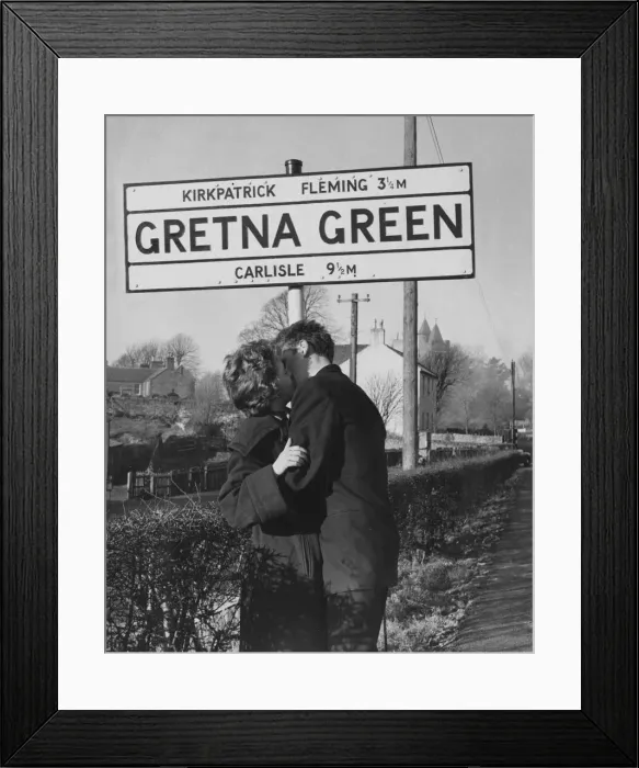 Framed Print : A young couple kissing under the Gretna Green Road sign