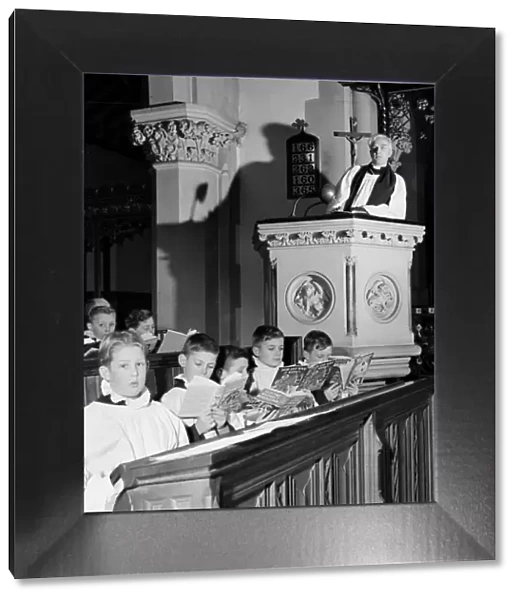 Choirboys reading their books in church during a priests sermon Circa 1954