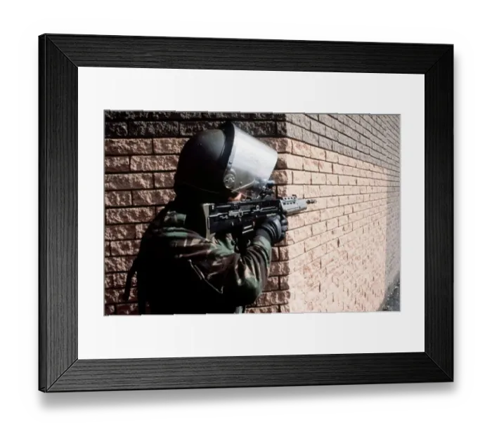Framed Print : Army Belfast An armed soildier talked aim round the corner of a building with his Framed Print : Army Belfast An armed soildier talked aim round the corner of a building with his