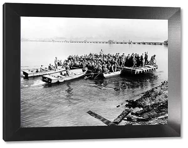 US army ferry German prisoners of war across the Rhine. US supplies cross by bridge
