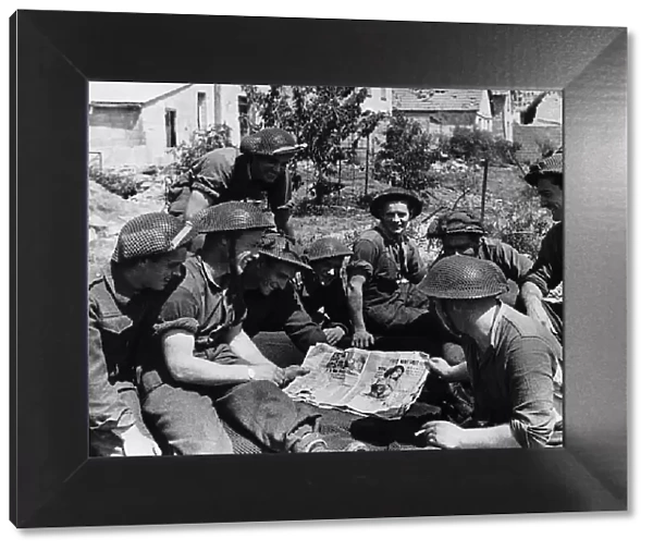 Soldiers during the invasion in France look at pin up pictures 1944