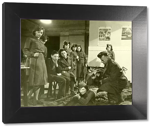 Mrs Olive carson taking rifle training instruction from Instructor while two of her