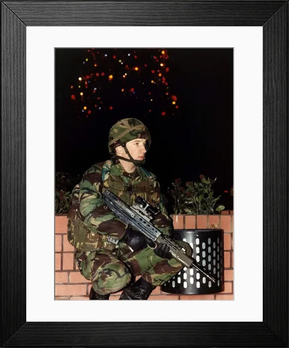 Framed Print : Army Soldier in camouflage uniform standing with a firearm in front of a Christmas tree Framed Print : Army Soldier in camouflage uniform standing with a firearm in front of a Christmas tree