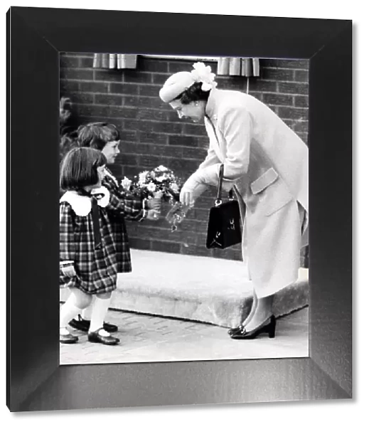 Queen Elizabeth II Four year old twins Sarah and Ruth McLeod giving the Queen
