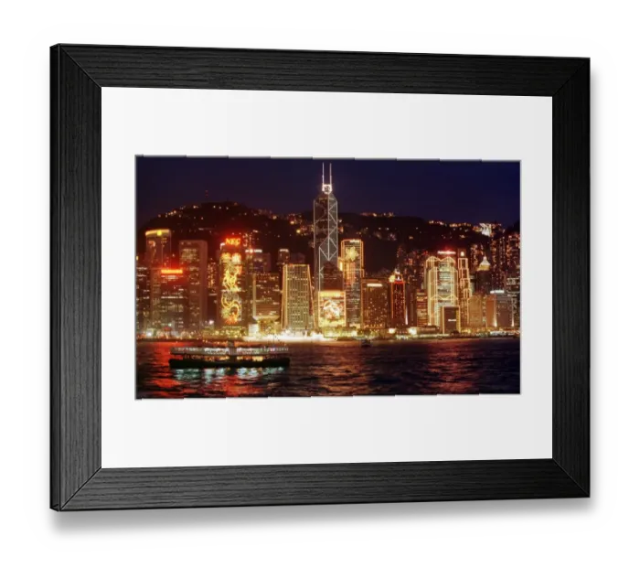 Framed Print : Hong Kong skyline seen from the harbour at night. The buildings are lit up for